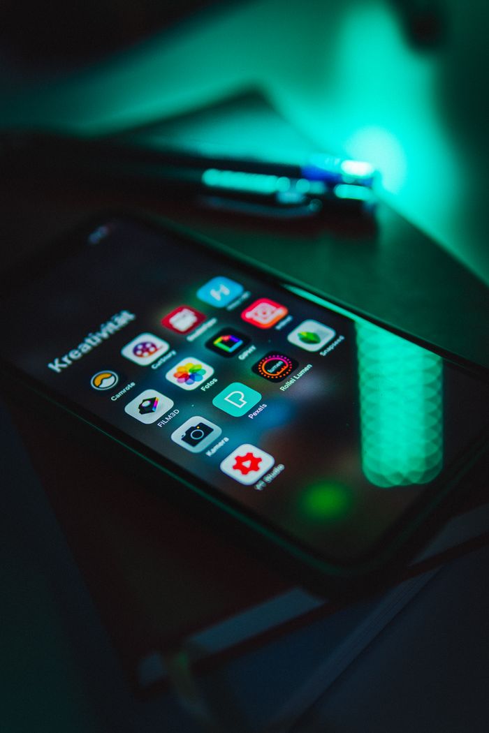Crafting Captivating Headlines: Your awesome post title goes here Smartphone displaying colorful app icons in low light, emphasizing technology and connectivity.